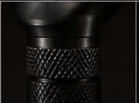 Macro study of a knurled black anodized aluminum surface, shown as a finish reference only. CORVO-001's own exterior is smooth and carries no knurling
